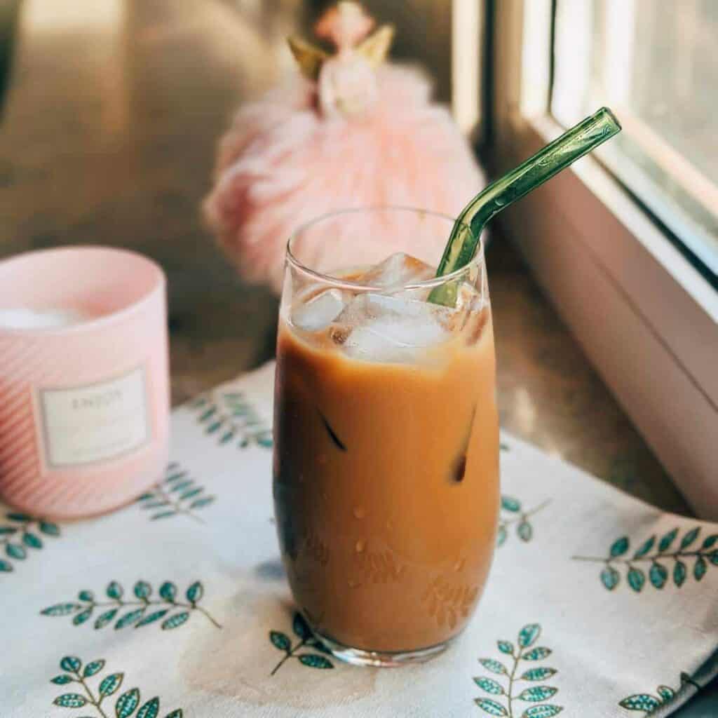 A glass of Earl Grey Caramel Milk Tea on window sill