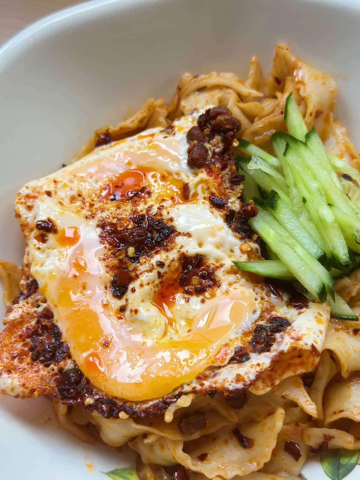 A visually enticing photo showcasing chili oil eggs prepared to perfection. The fried eggs are bathed in a rich, aromatic chili oil, creating a striking contrast of colors. The eggs have a golden, crispy exterior, while the chili oil adds a spicy and flavorful twist