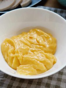 A close-up photo of homemade Vietnamese Mayo, a creamy and rich sauce used in Vietnamese cuisine. It has a smooth and velvety texture, perfect for enhancing the flavor of Banh Mi sandwiches and other Vietnamese dishes.