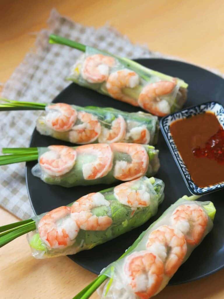 Delicious and refreshing Gỏi Cuốn - Vietnamese fresh spring rolls filled with succulent shrimp, tender slices of pork belly, crisp lettuce, rice vermicelli, and fragrant fresh herbs. Wrapped in translucent rice paper, these vibrant rolls are served with a tantalizing dipping sauce.
