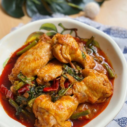 Delicious Thai Stir-Fried Chicken with Red Curry (Pad Ped Gai) - A mouthwatering and aromatic dish served with steamed rice, featuring tender chicken, vibrant vegetables, and rich red curry flavors.
