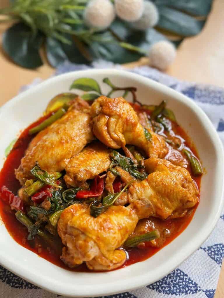 Delicious Thai Stir-Fried Chicken with Red Curry (Pad Ped Gai) - A mouthwatering and aromatic dish served with steamed rice, featuring tender chicken, vibrant vegetables, and rich red curry flavors.