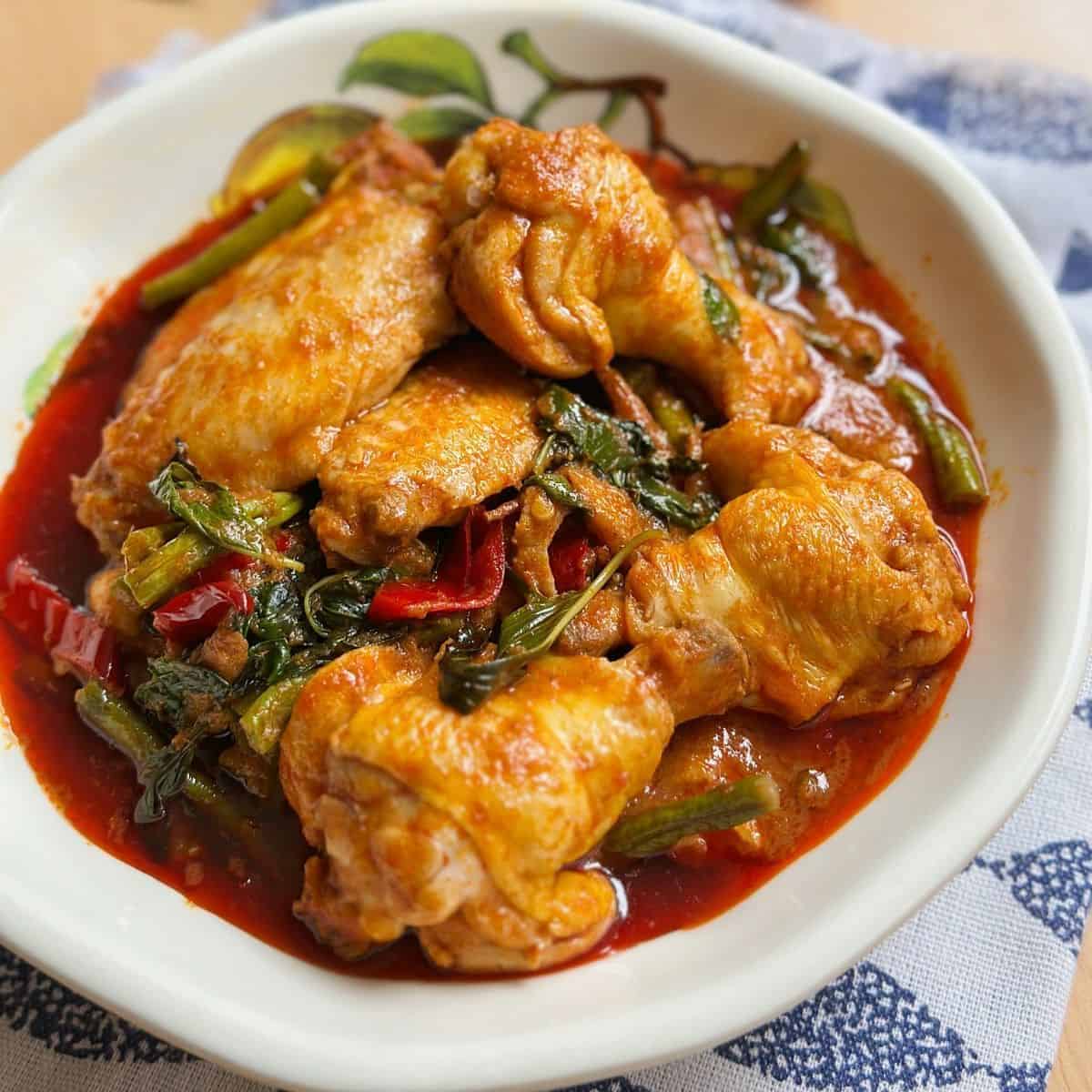 Delicious Thai Stir-Fried Chicken with Red Curry (Pad Ped Gai) - A mouthwatering and aromatic dish served with steamed rice, featuring tender chicken, vibrant vegetables, and rich red curry flavors.