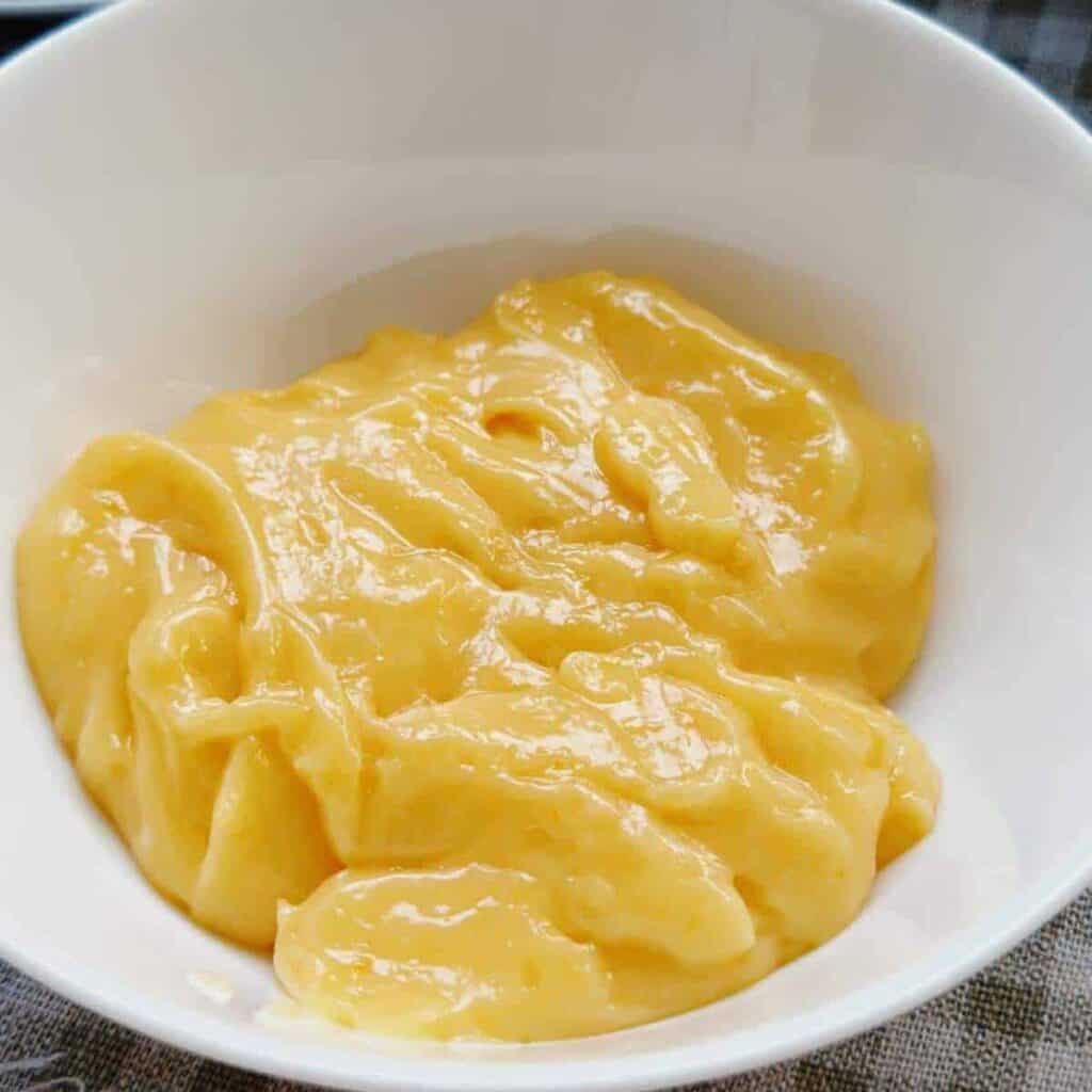 A close-up photo of homemade Vietnamese Mayo, a creamy and rich sauce used in Vietnamese cuisine. It has a smooth and velvety texture, perfect for enhancing the flavor of Banh Mi sandwiches and other Vietnamese dishes.