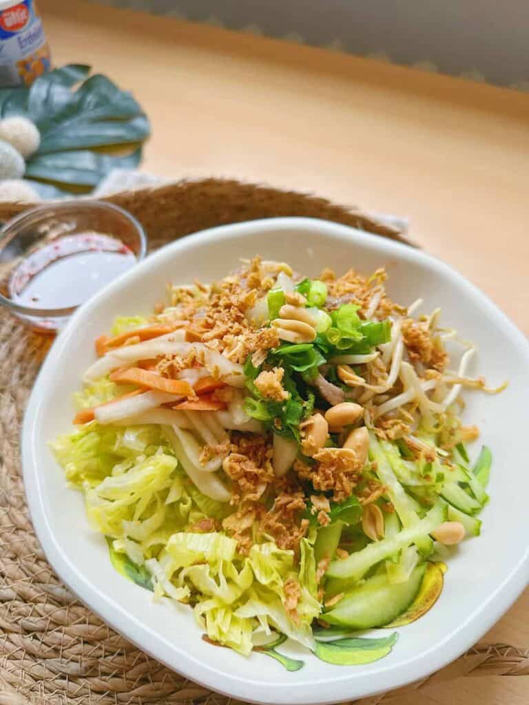 Delicious Vietnamese Bun Bo Xao - A flavorful noodle salad dish with tender stir-fried beef, fresh herbs, and rice noodles, topped with peanuts and served with Vietnamese dipping sauce.