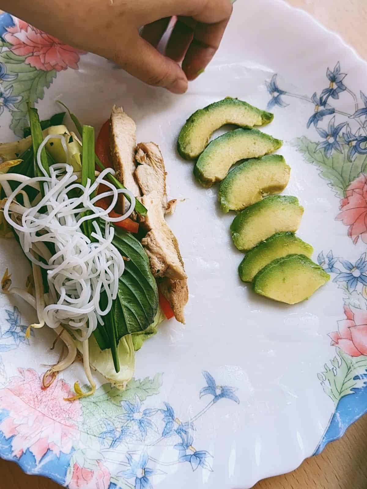 Sommerrollen mit Hähnchen (Chicken Summer Rolls) Assemble: rolling rice papers with the filling of rice noodles, vegetables and chicken.