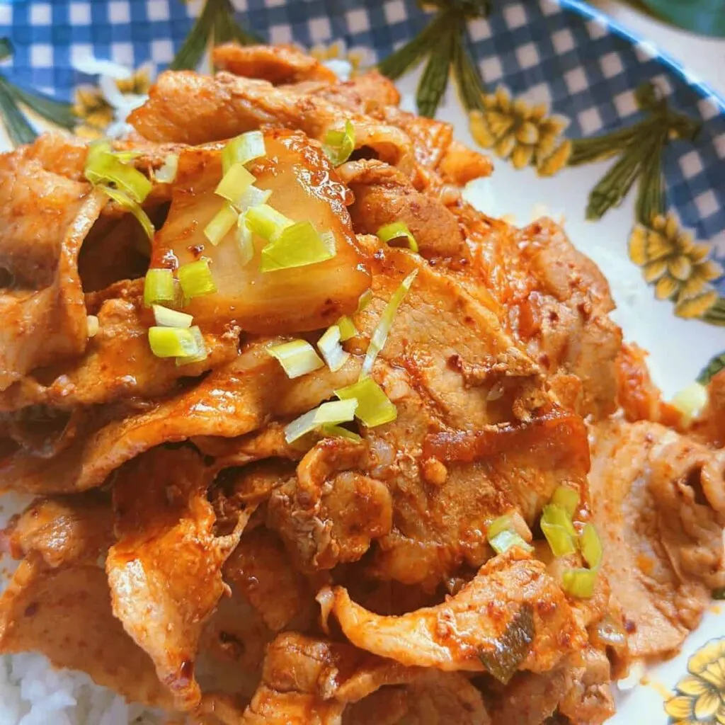 Enoki Beef Rolls Over Rice (Super Easy) Korean Kimchi Duruchigi dish: A sizzling stir-fry of thinly sliced marinated pork, vibrant kimchi, and assorted vegetables.