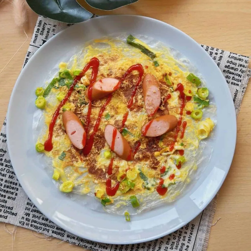 Vietnamese Spring Rolls with Peanut Sauce | Gỏi Cuốn A mouthwatering plate of Bánh Tráng Nướng, Vietnamese Pizza, with a crispy golden-brown texture. Topped with a flavorful combination of eggs, scallions, and a variety of savory ingredients.