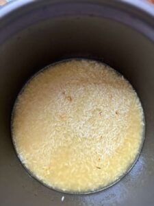 rice and chicken broth in the pot of rice cooker