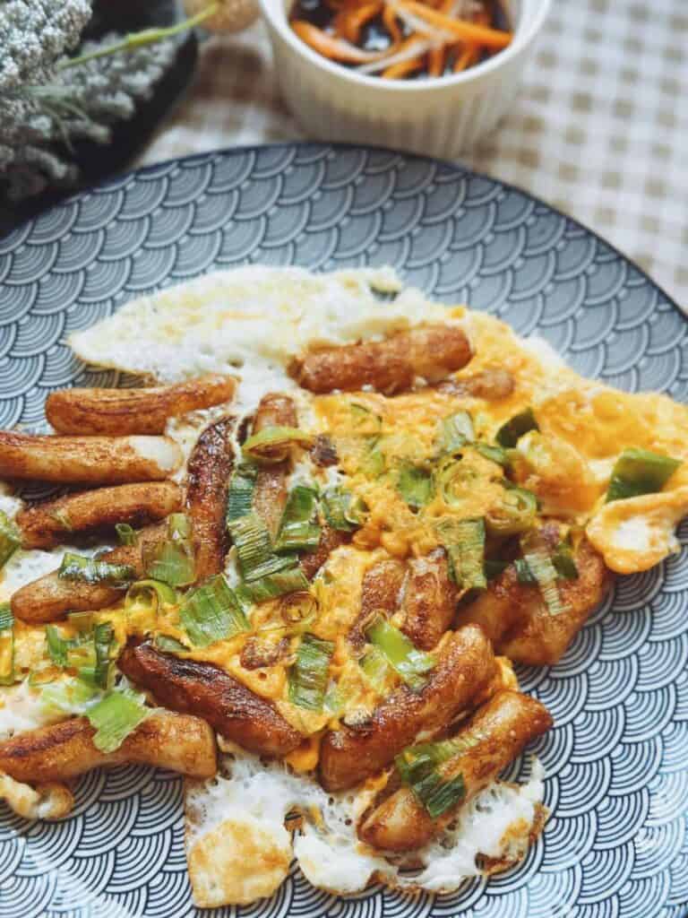 Delicious plate of Bột Chiên, crispy fried rice cakes with eggs and scallions, served with a flavorful dipping sauce
