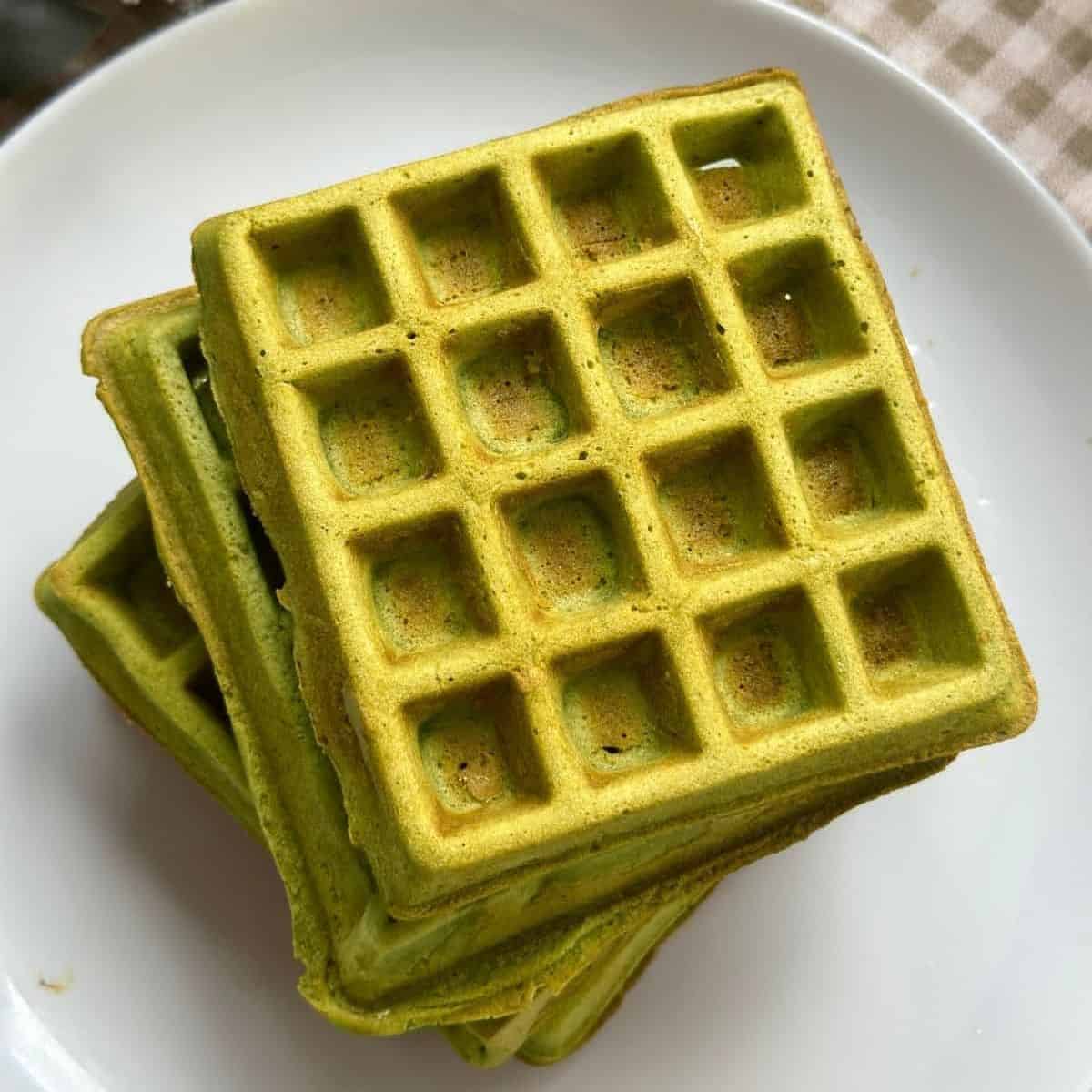 Freshly made matcha waffles with a golden crispy exterior and a soft green tea-infused interior.