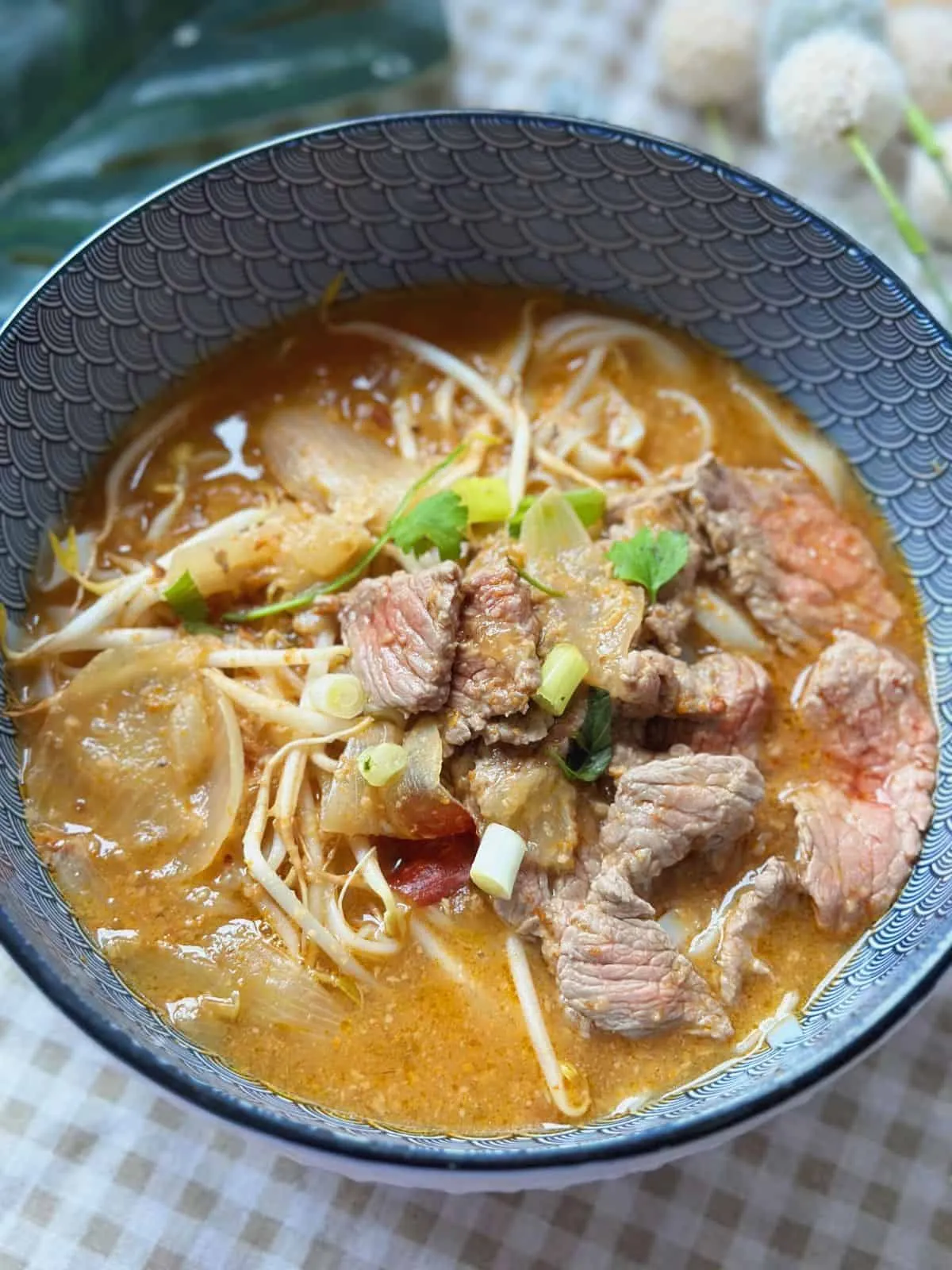 Phở Sate (Spicy Beef Satay Pho) Steaming bowl of Pho Sa Tế with flat rice noodles, rich satay broth, and an assortment of fresh toppings