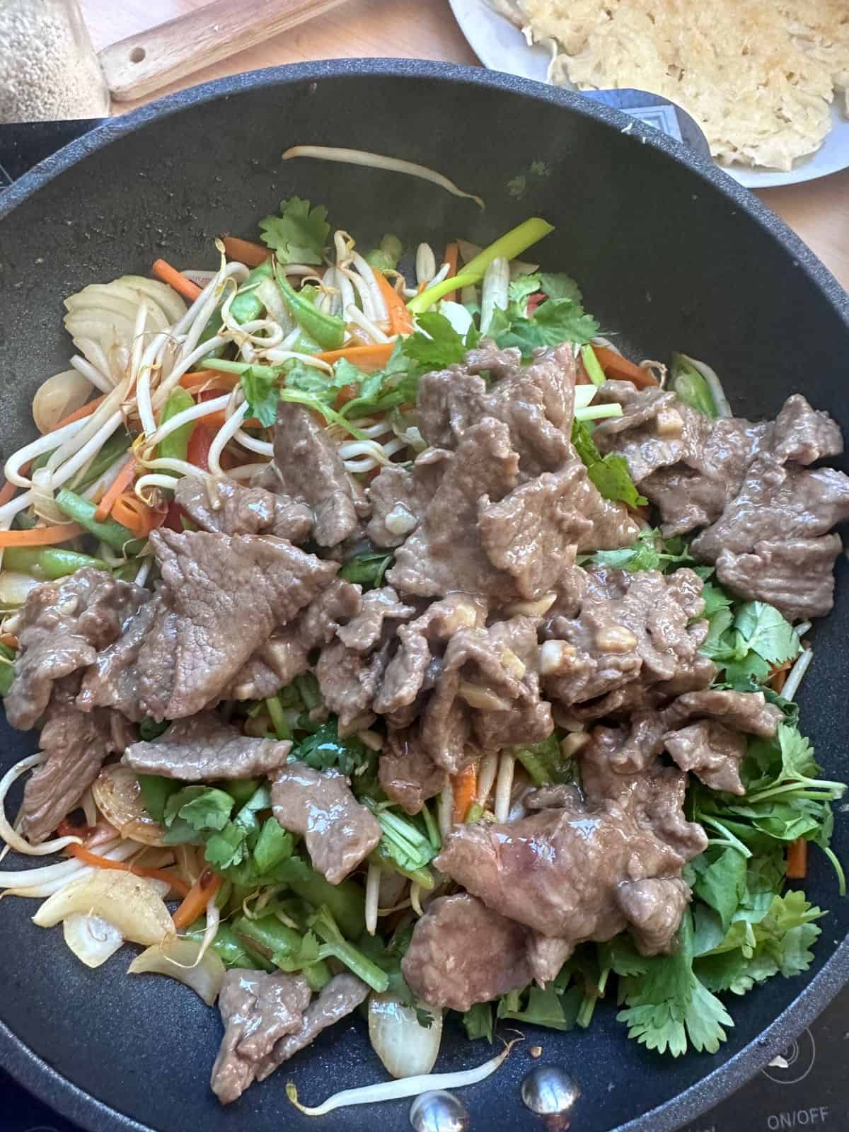 Vietnamesische Knusprig Gebratene Reisnudeln | Phở Áp Chảo stir-fried beef and vegetables for Pho xao gion in a pan