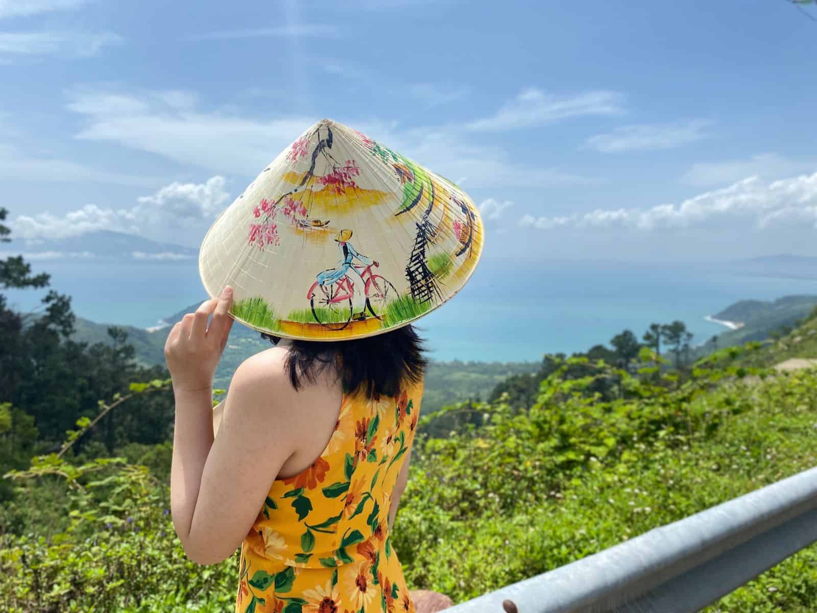 20 Must-Have Vietnamese Souvenirs to Bring Home in 2025 A Vietnamese girl wearing "non la"
