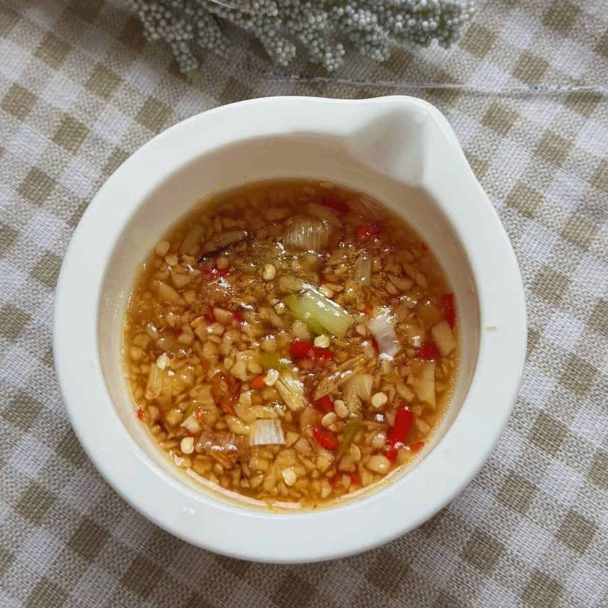 A small bowl filled with zesty ginger fish sauce, a popular Vietnamese condiment