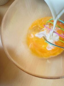 Pour the milk into the eggs.