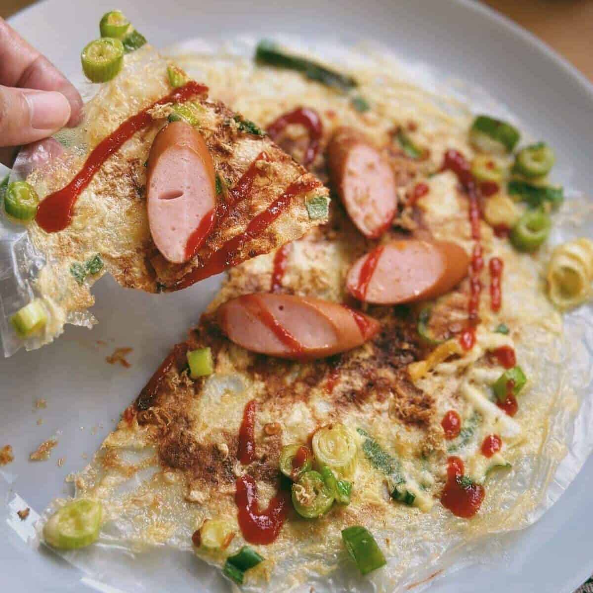 A delicious plate of Banh Trang Nuong, also known as Vietnamese rice paper pizza. This Vietnamese pizza recipe features a crispy rice paper base topped with a variety of flavorful ingredients, resulting in a mouthwatering and unique culinary delight.