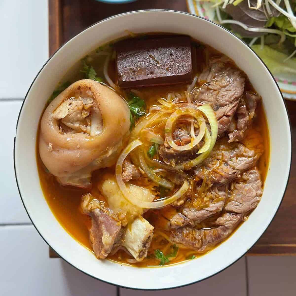 a bowl of Bún Bò Huế (Vietnamese spicy beef noodle soup)