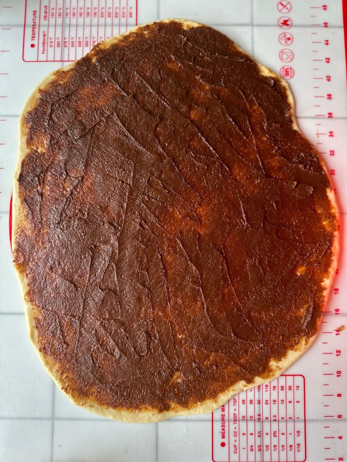 Die Füllung gleichmäßig auf dem Teig verstreichen.
