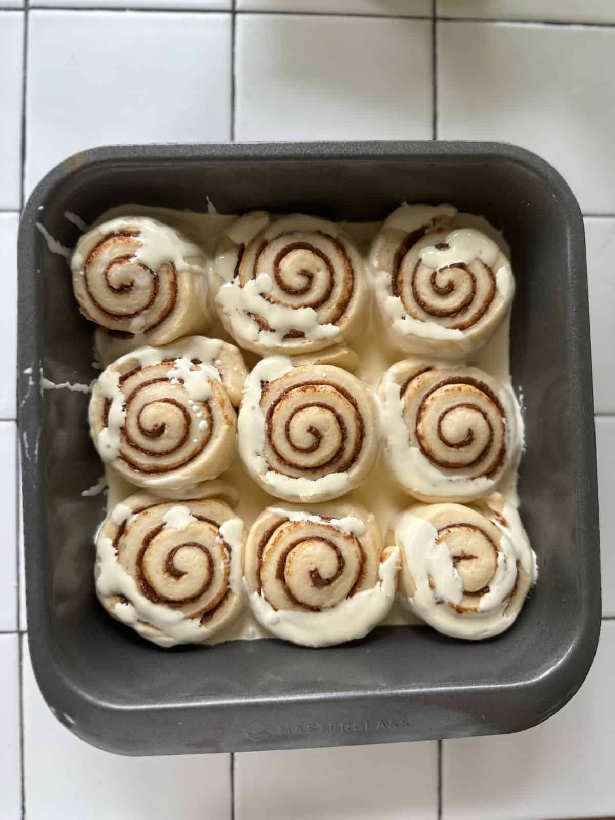 Vor dem Backen die Schlagsahne über die Zimtschnecken gießen.