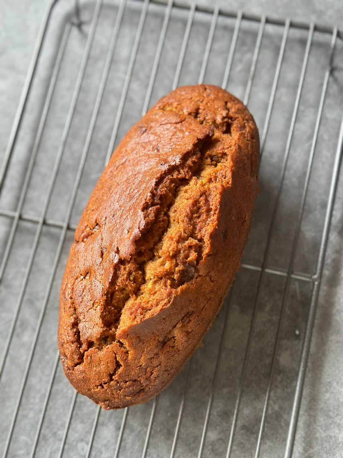 Bester Bananenkuchen – Saftig & Einfach Gelingsicher Frisch gebackener Bananenkuchen mit goldbrauner Kruste, abkühlend auf einem Kuchengitter von oben fotografiert.