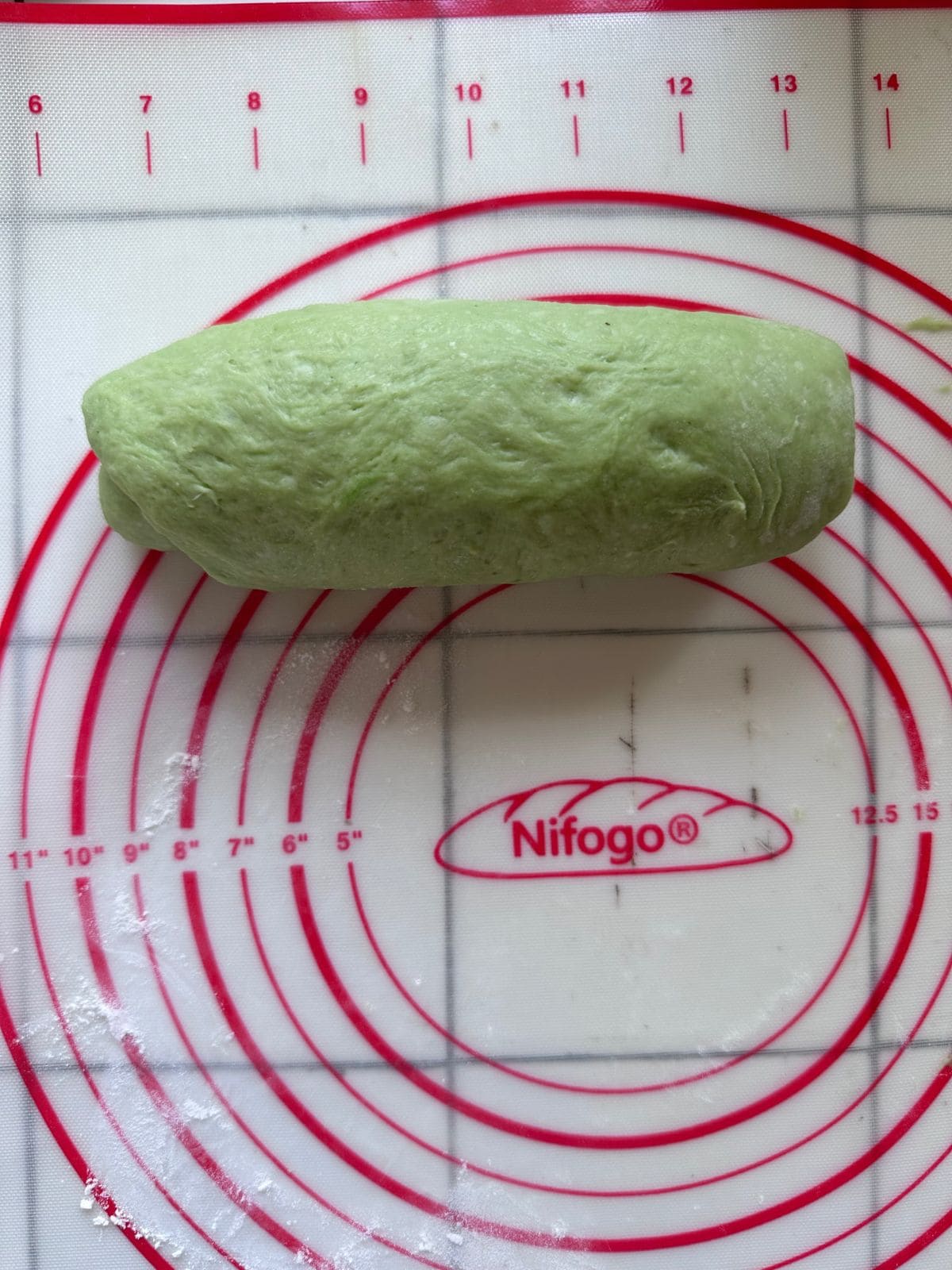Pillow-Soft Pandan Bread (Vegan) Green dough rolled into a short, thick log placed on the silicone baking mat.