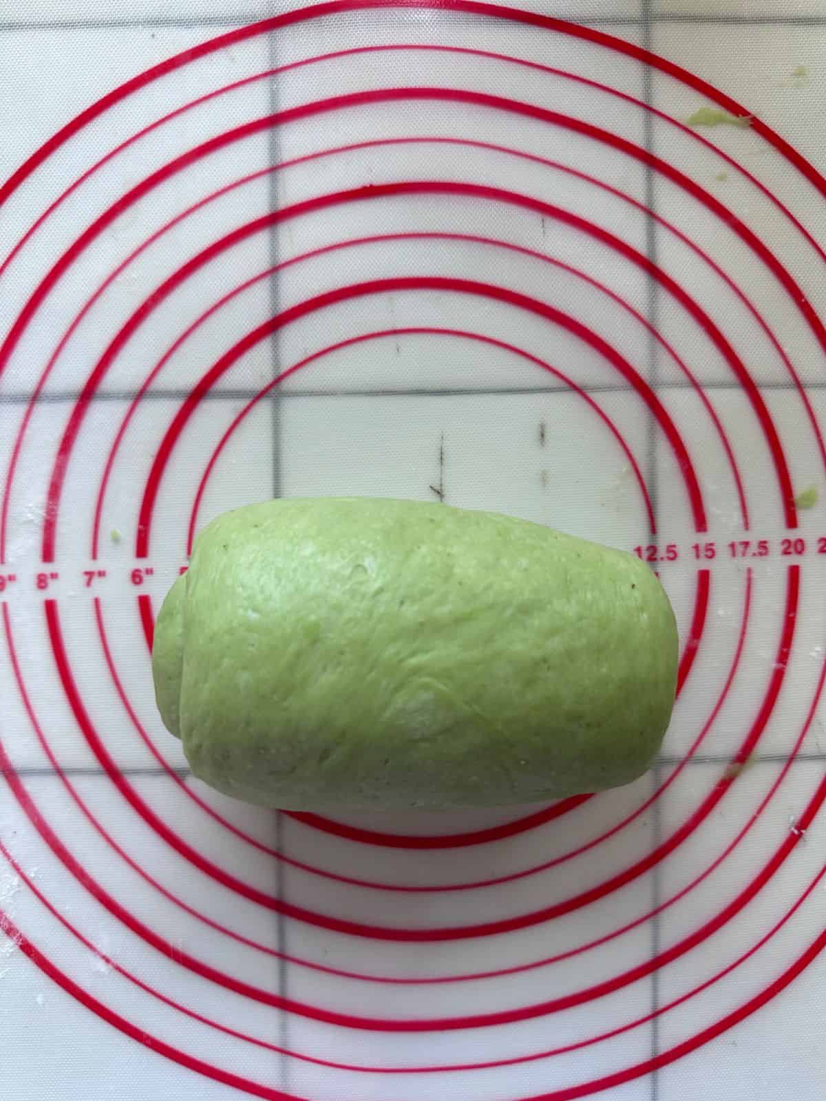 Pillow-Soft Pandan Bread (Vegan) Green dough rolled tightly into a smooth log shape.