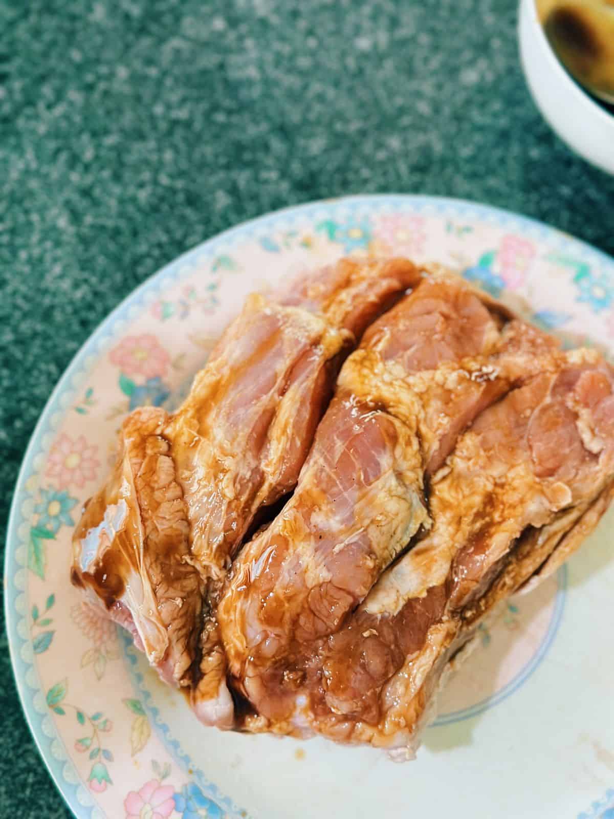The meat side of the pork belly after being marinated with a Vietnamese-style seasoning mix of hoisin sauce, garlic powder, five-spice powder, and salt.