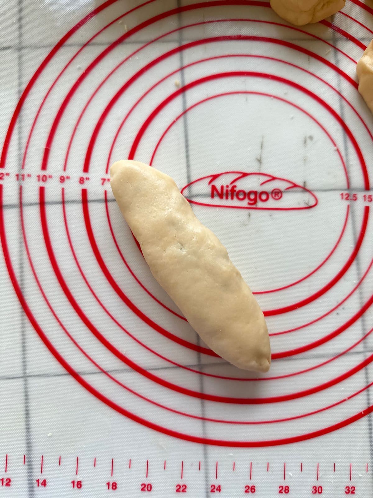 A rolled dough log on a pastry mat, enclosing the yam filling inside.