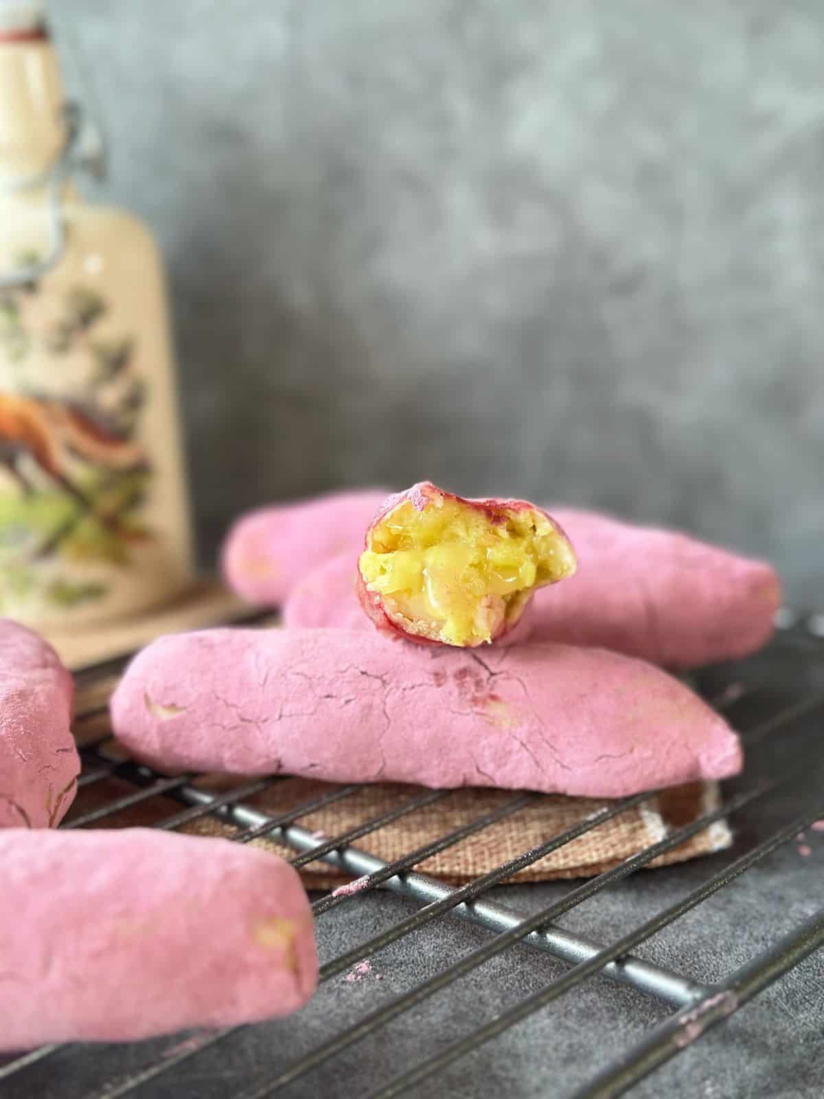 A halved Korean sweet potato bun reveals its gooey, cheesy filling.