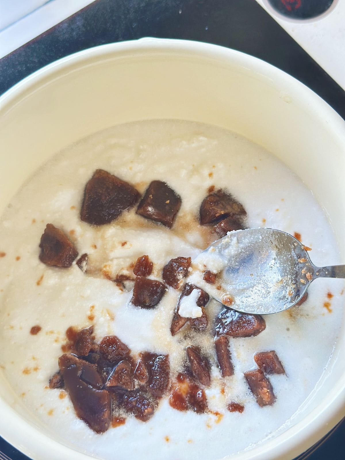 Palm sugar mixed with coconut milk in a pot.