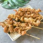 Juicy Vietnamese grilled pork skewers served on a plate, garnished with sesame seeds