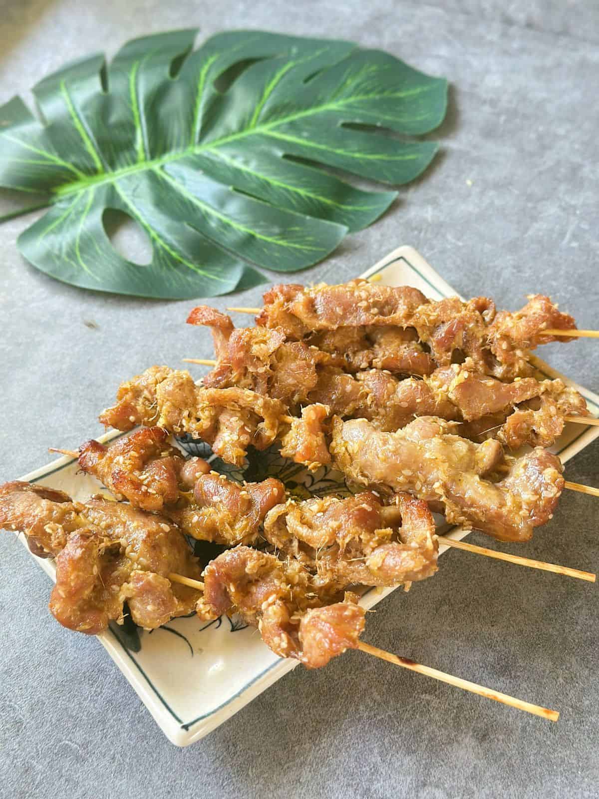 Juicy Vietnamese grilled pork skewers served on a plate, garnished with sesame seeds