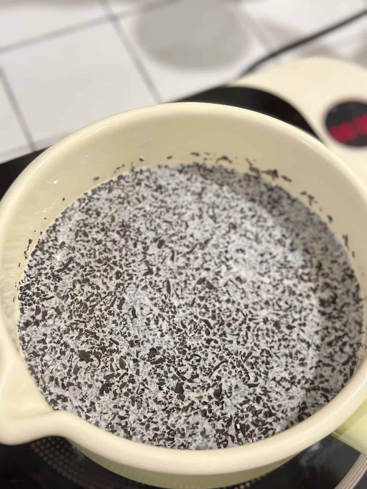 Close-up of loose tea simmering gently in milk.