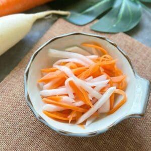 Vietnamesisch Eingelegte Karotten & Daikon-Rettich: Đồ Chua Close-up of Đồ Chua, thinly sliced pickled carrots and daikon in a small white bowl.