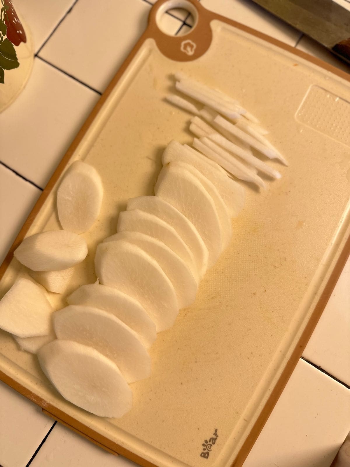 Vietnamesisch Eingelegte Karotten & Daikon-Rettich: Đồ Chua Daikon cut into matchsticks on a cutting board, prepared for pickling.