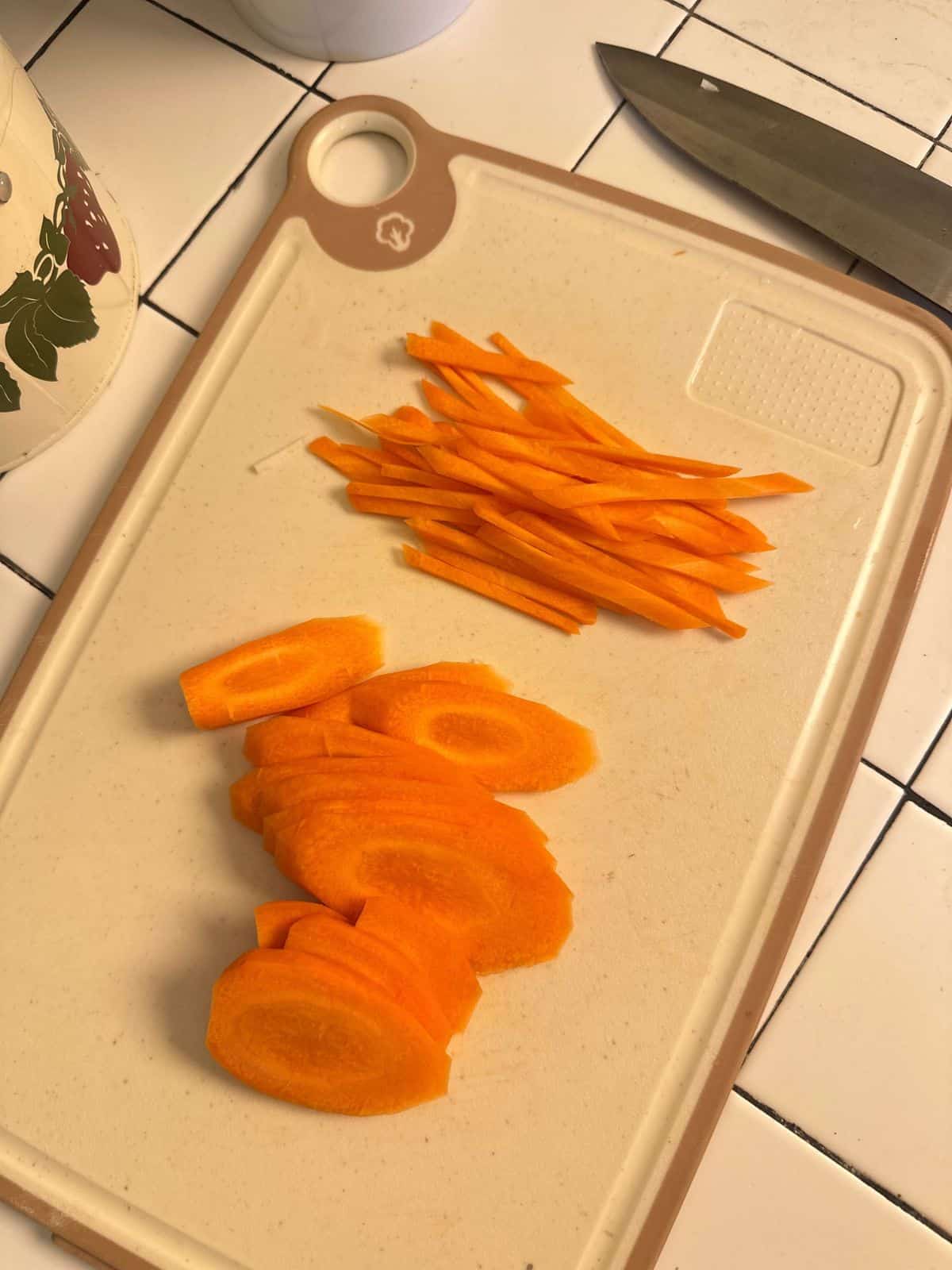 Vietnamesisch Eingelegte Karotten & Daikon-Rettich: Đồ Chua Carrot matchsticks on a cutting board, ready for pickling.