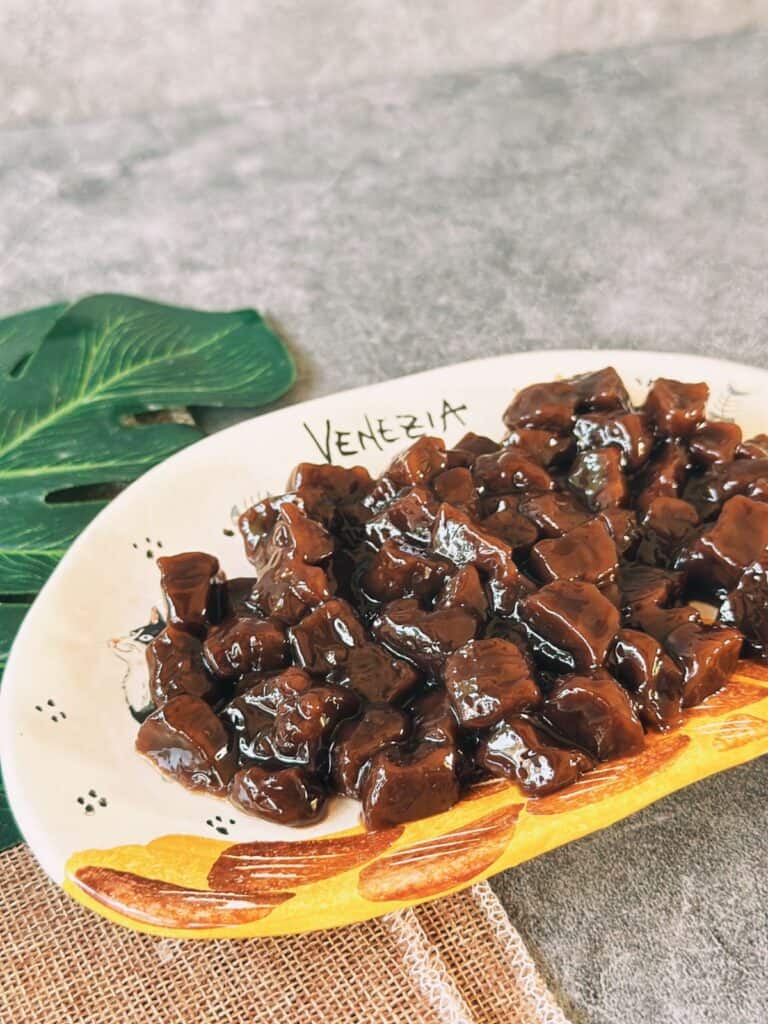 How To Make Boba Pearls / Tapioca Pearls (5-minute Boiled) A plate of glossy, cooked boba pearls coated in syrup, glistening and ready to add to milk tea.