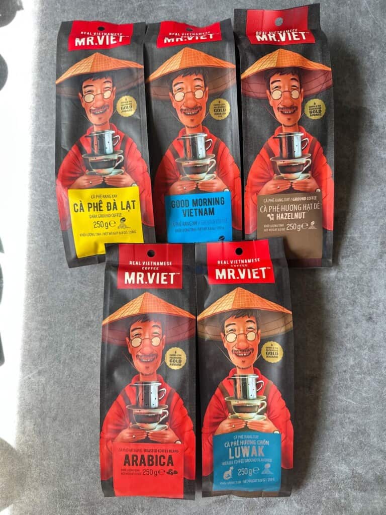 Assorted Mr Viet coffee blend bags in vibrant red packaging, featuring the signature smiling man in a nón lá hat.