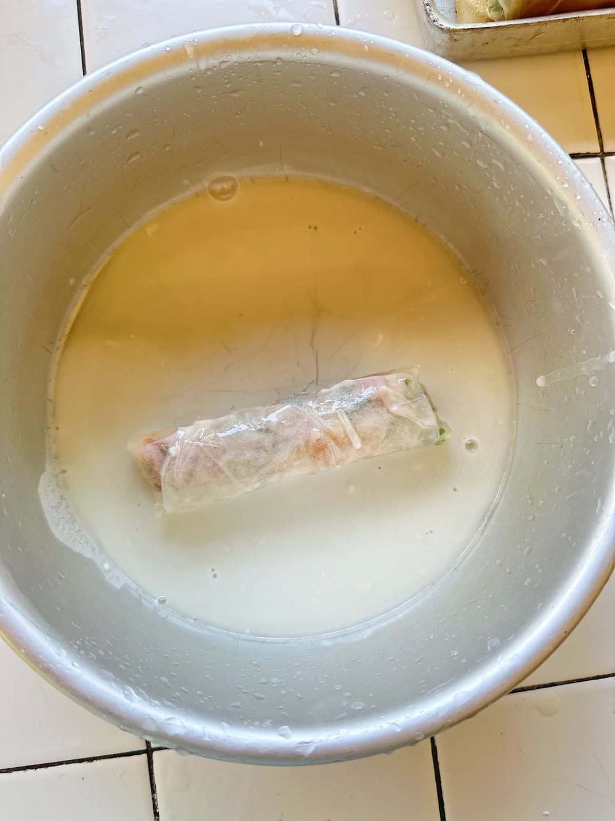 Frühlingsrollen aus Vietnam (Vietnamese Spring Rolls) A spring roll being coated in a thin flour batter mixture to create an extra-crispy texture when fried.
