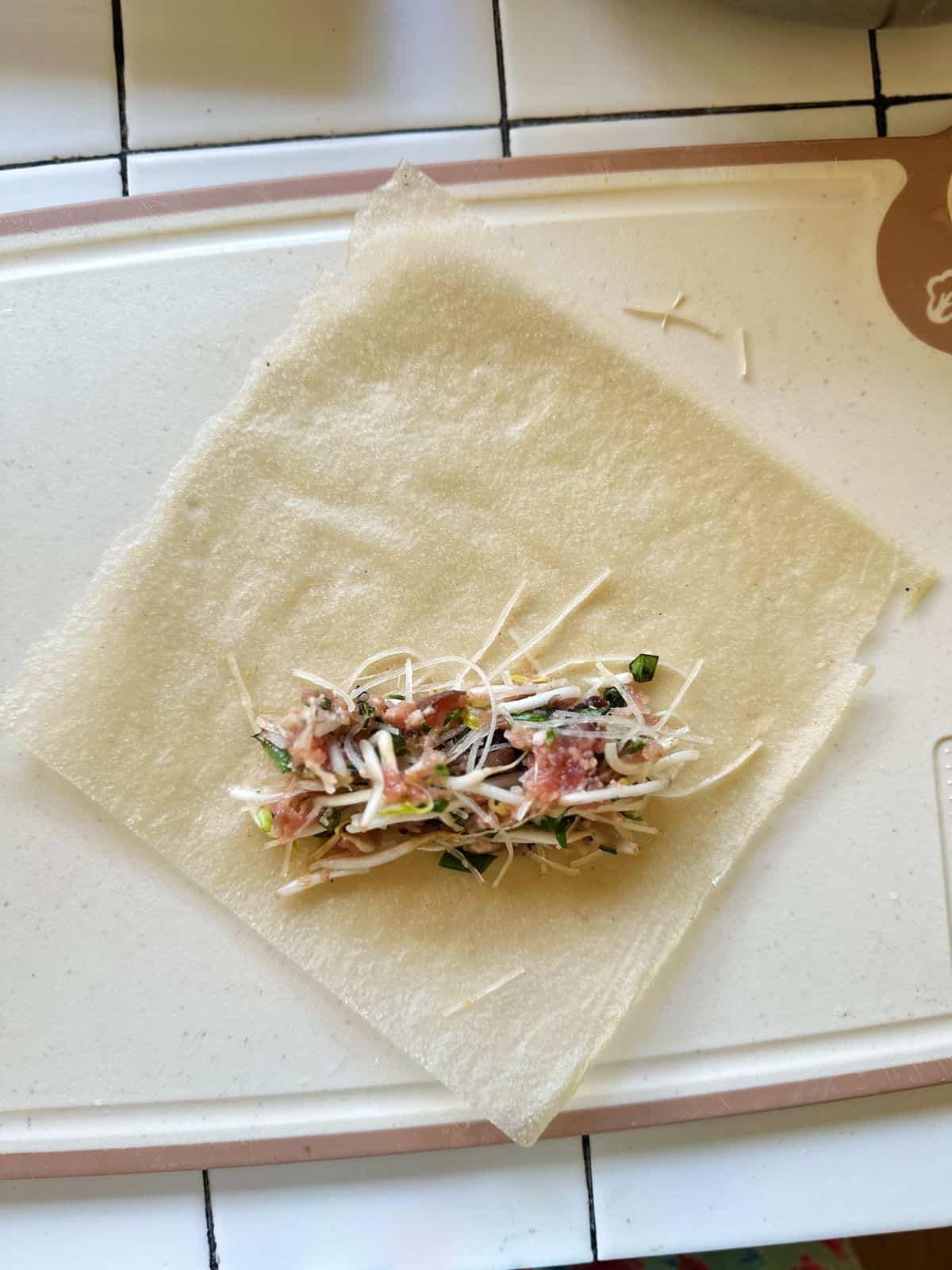 Frühlingsrollen aus Vietnam (Vietnamese Spring Rolls) Place the square wrapper on the surface (or cutting board) with one corner pointing toward you so it forms a diamond shape. Spoon about 2 tbsps filling just below the center of the square one.