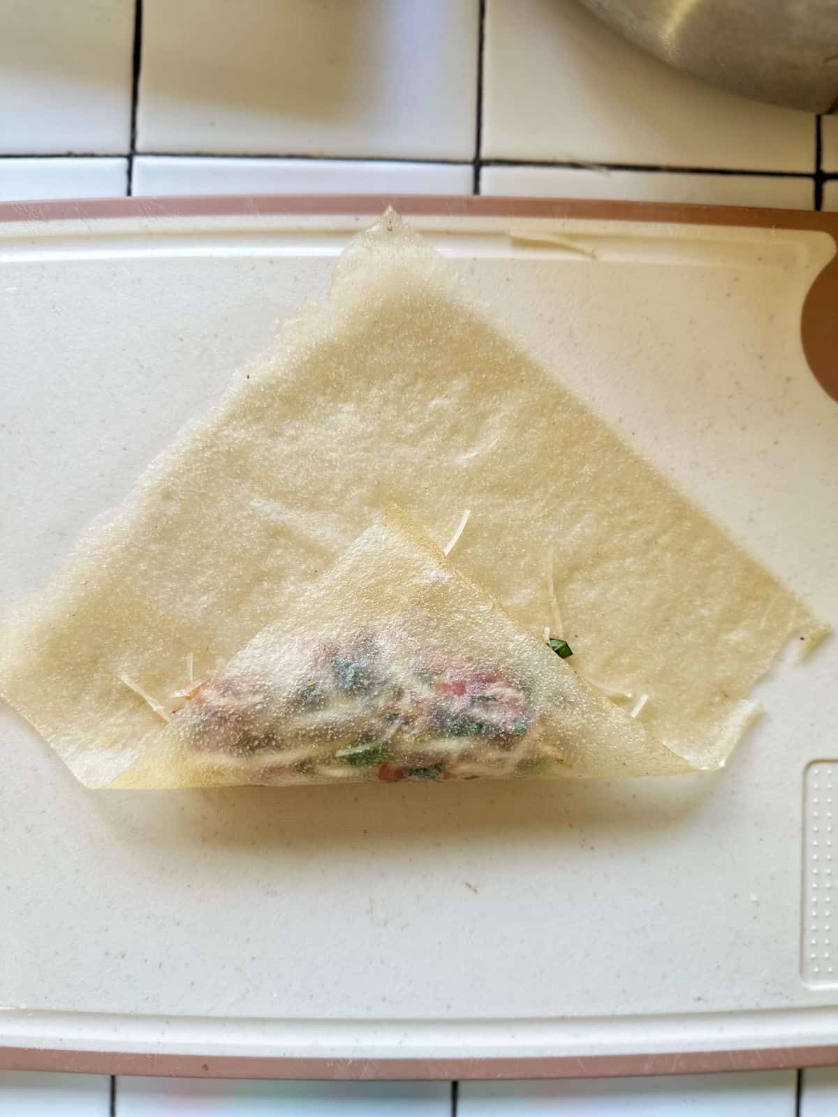 Frühlingsrollen aus Vietnam (Vietnamese Spring Rolls) Lift the bottom corner and fold it tightly over the filling, tucking it in gently to keep everything snug.
