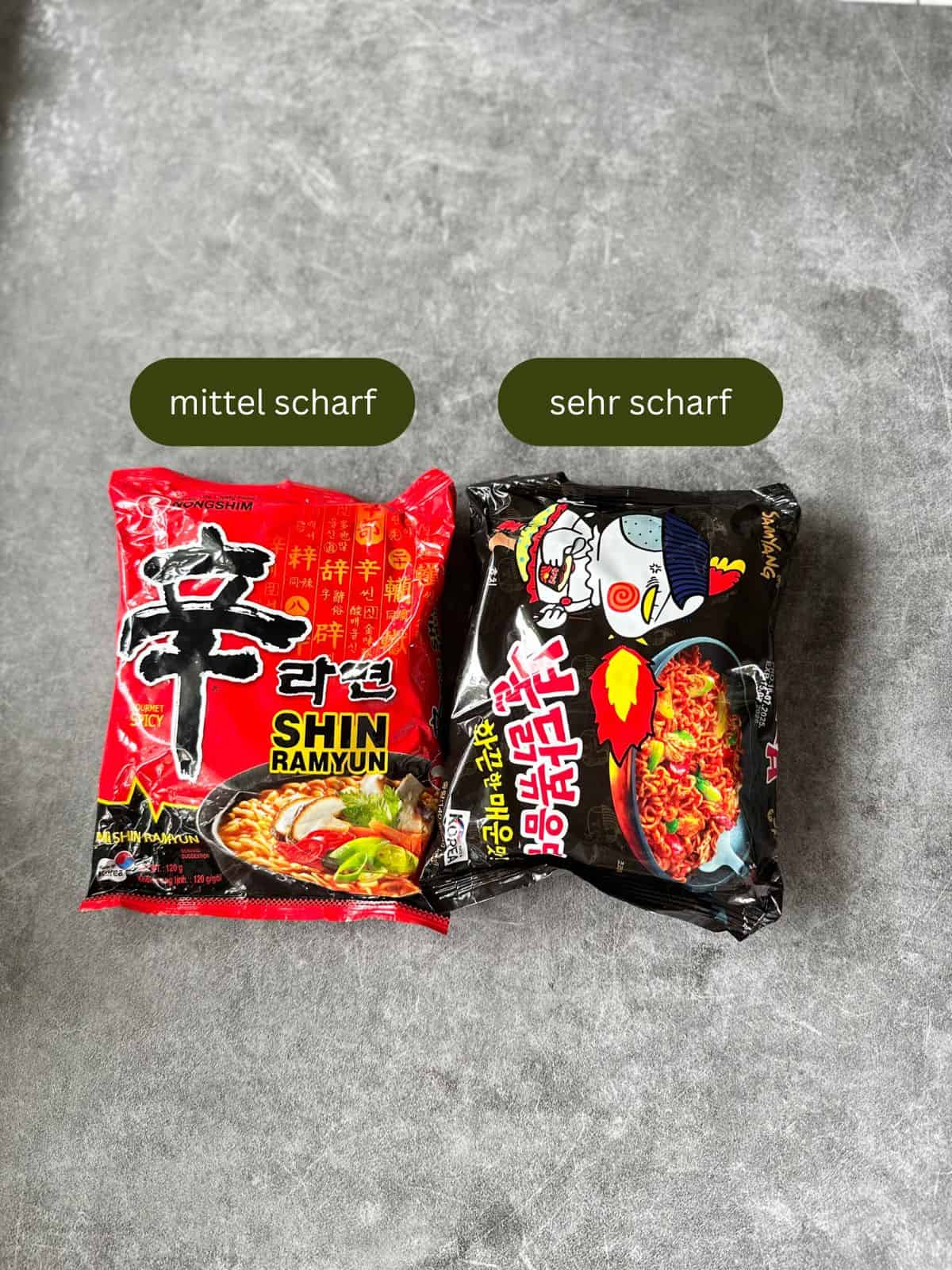 Zwei Packungen Ramyeon für Rabokki – eine mit „mittel scharf“, die andere mit„stark scharf“ gekennzeichnet.