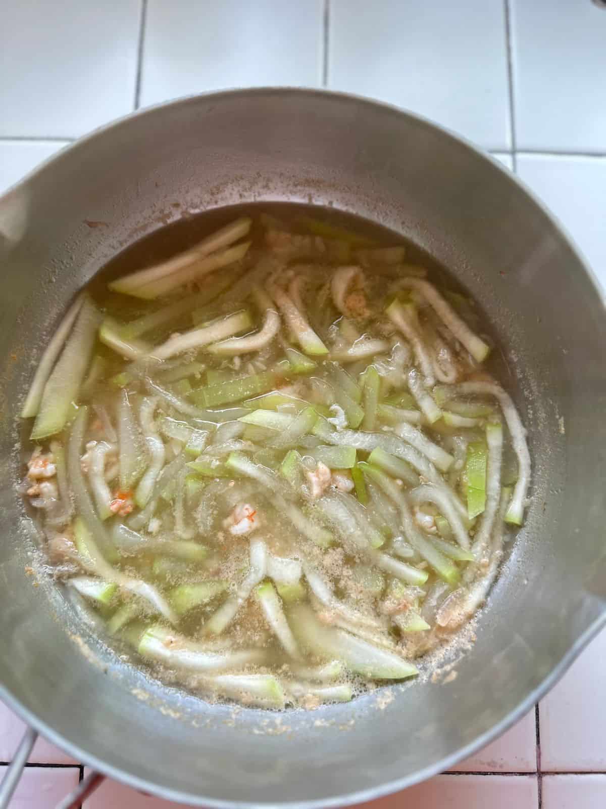 Freshly cooked Canh Bầu Tôm in a pot, with tender squash and pink shrimp in a light broth.