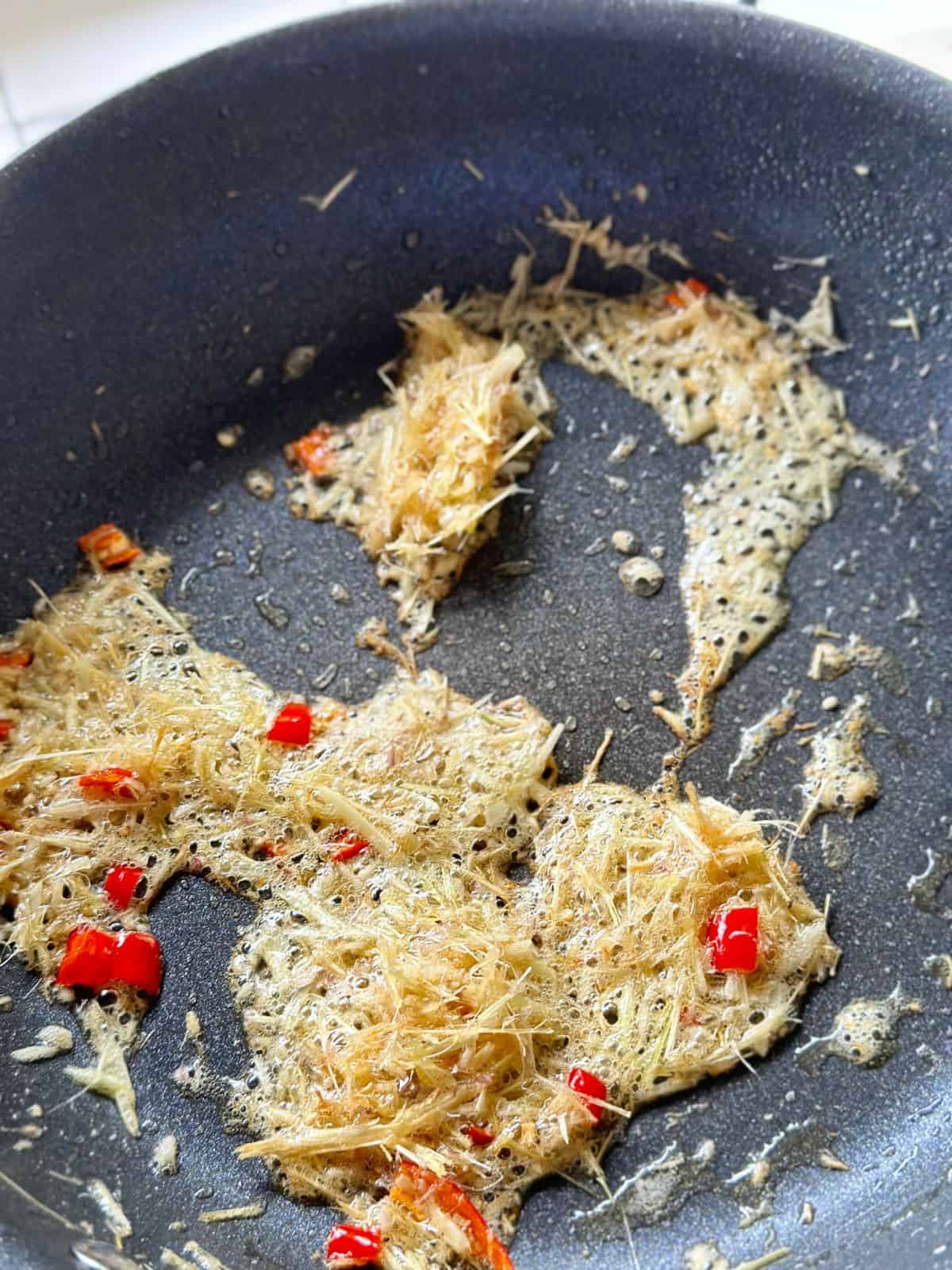Minced lemongrass and chili stir-fried in a skillet until the lemongrass turns slightly golden.