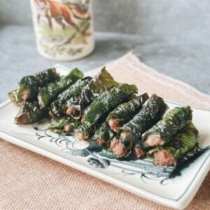 Grilled bo la lot—juicy beef wrapped in wild betel leaves—arranged on a plate.