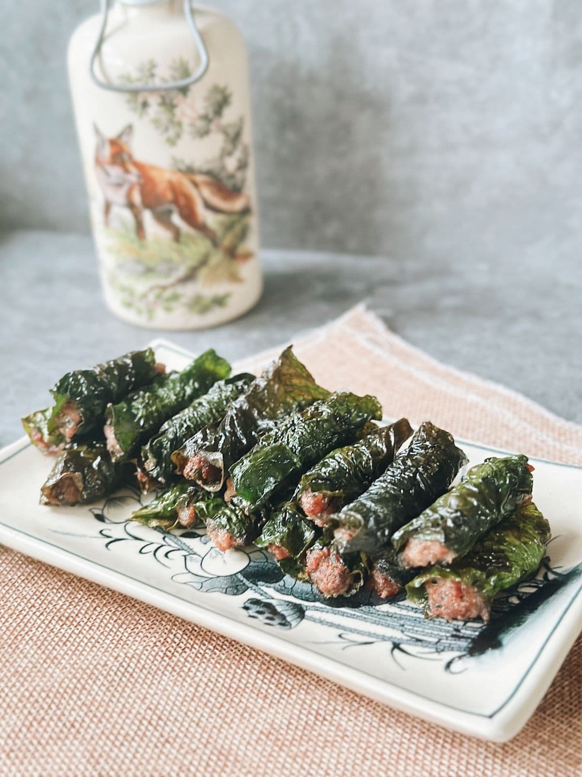 Grilled bo la lot—juicy beef wrapped in wild betel leaves—arranged on a plate.