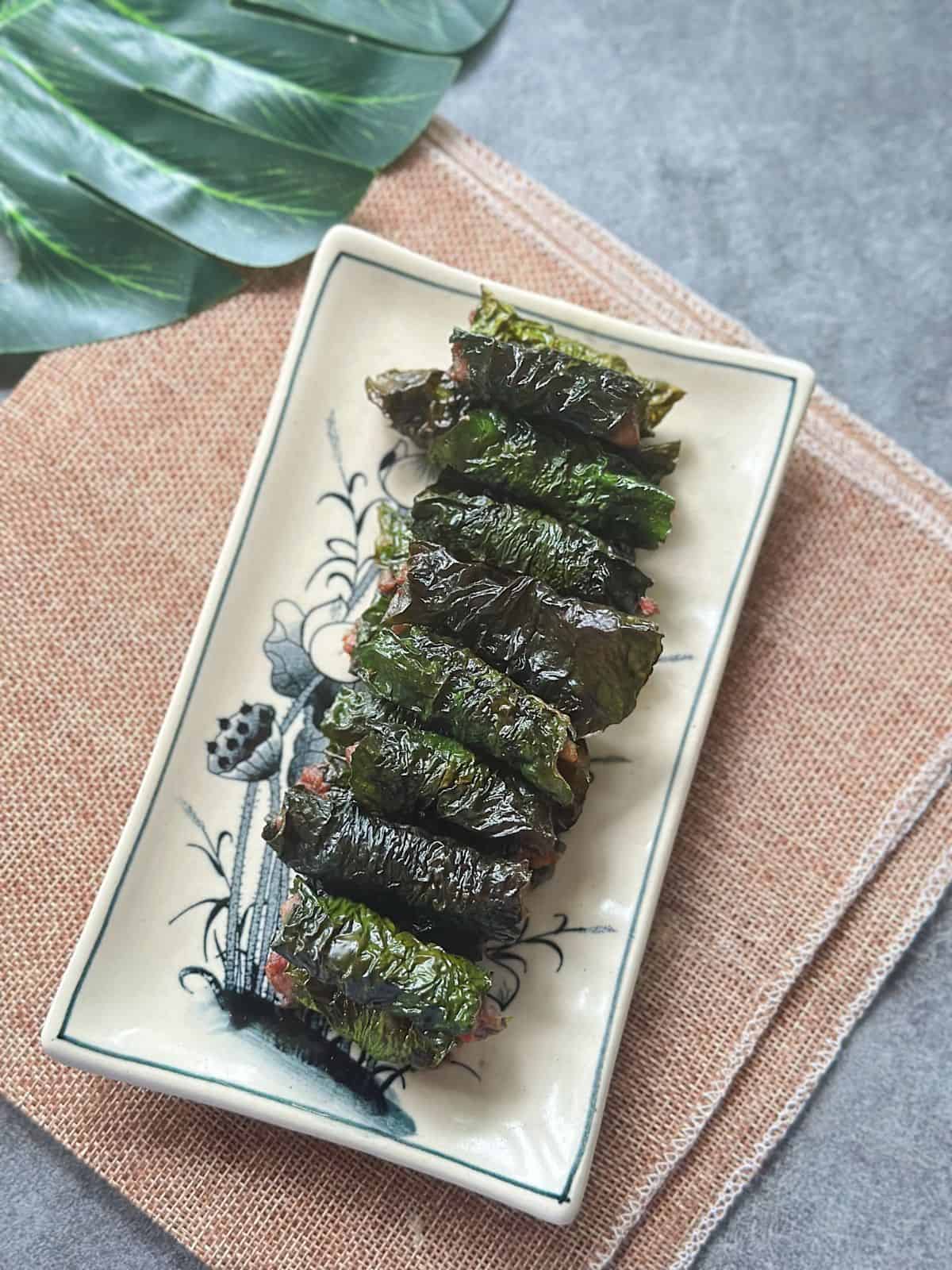 Grilled bo la lot—juicy beef wrapped in wild betel leaves—arranged on a plate.