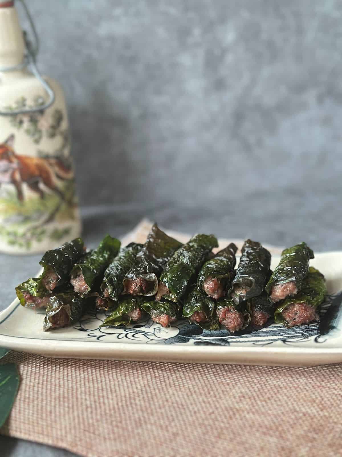 Grilled bo la lot—juicy beef wrapped in wild betel leaves—arranged on a plate.